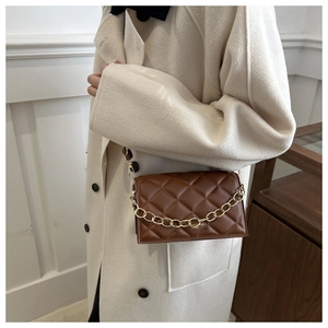 Brown quilted crossbody bag featuring large diamond stitching and a gold chunky chain strap