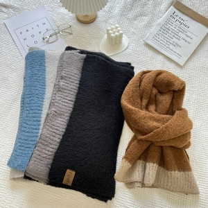 Close-up of soft cashmere-like scarves with fringe and leather tags in warm colors