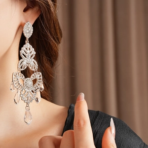 Close-up of a silver chandelier earring with sparkling crystals and teardrop fringes