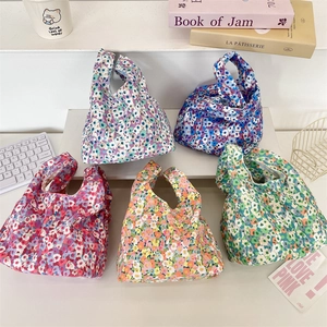 Detailed flat lay of small corduroy floral wrist bags in diverse colorful patterns