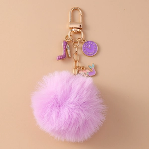 Detail showing purple faux rabbit fur ball keychain with clock and mermaid charms