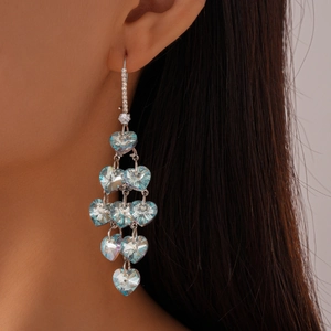 Vue latérale de boucles d'oreilles cœur vintage en cristal bleu clair et finition argent