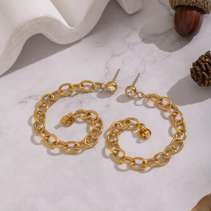 Macro view of gold chain link hoop earrings with sparkling round zircon stone detail