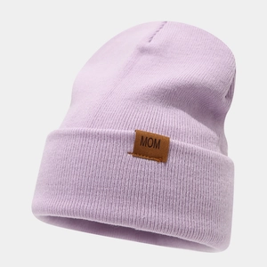 Close-up of light purple knitted beanie featuring a brown leather patch with MOM text