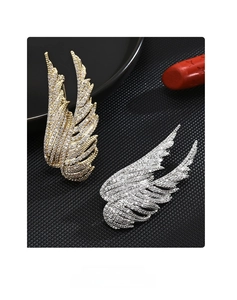 Detailed view of luxury wing-shaped brooches with sparkling zircon stones in gold and silver