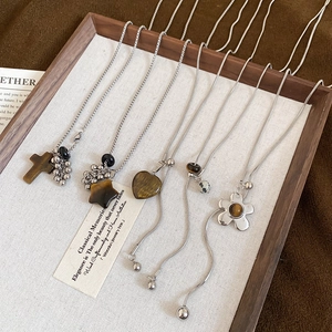 Close-up of stainless steel tiger eye stone necklaces displayed on a wooden jewelry tray