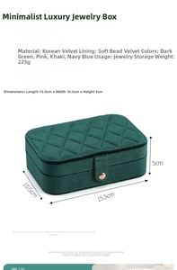 Detail view of emerald green velvet jewelry box with quilted pattern and gold metal clasp