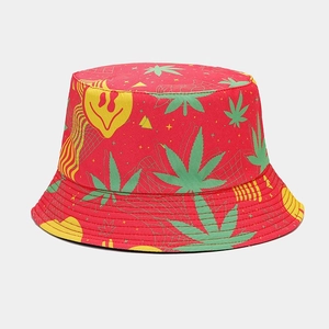 Detail of red bucket hat featuring green leaf print and yellow melting smiley face graphic