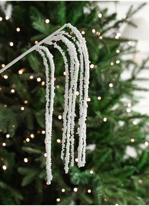 Detailed view of white pearl beaded branches hanging on a decorated Christmas tree
