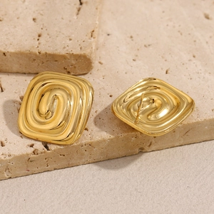Boucles d'oreilles labyrinthe carrées en acier doré 18K sur pierre texturée