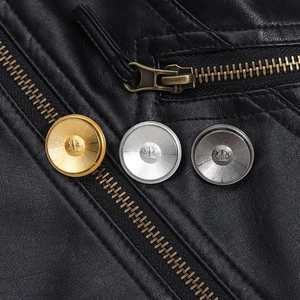 Close-up of metallic buttons in gold, silver, and grey on a black leather jacket