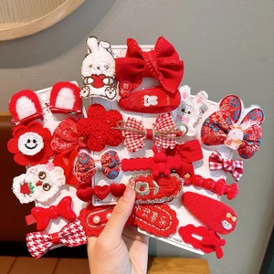 Detail of red festive children's hair clips with rabbits and traditional patterns