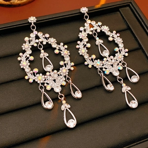 Detailed macro of silver flower earrings with rainbow crystals and teardrop pendants