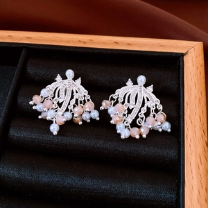 Detail of luxury fringe earrings with pearls and crystal beads on a black velvet tray
