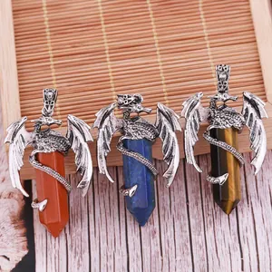 Trois pendentifs en cristal hexagonal en forme de dragon sur un fond de bois naturel