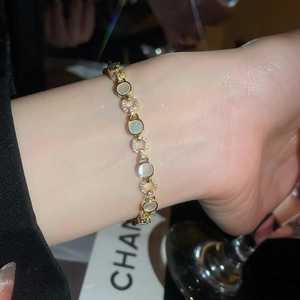 Détail d'un bracelet de luxe doré avec cristaux de zircon et inserts en nacre blanche