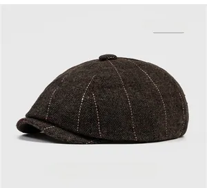 Close-up of coffee brown herringbone newsboy cap with wool texture and red stitching