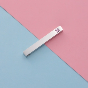 Detail view of mirror stainless steel bar pendant with inlaid pink square diamond accent