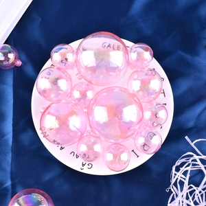 Macro detail of various sized pink transparent bubble cake toppers on a decorative plate