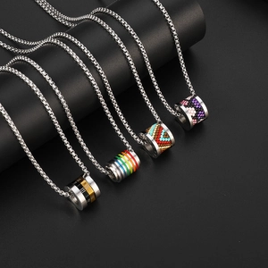 Detail view of cylinder pendants with Roman numerals and colorful beads on box chains