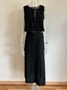 Detail of black two-piece set with pleated texture, sleeveless tie-front top and long skirt