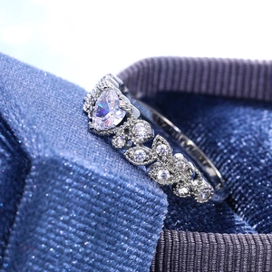 Blue heart-shaped zircon ring with round and marquise side stones on a blue velvet box