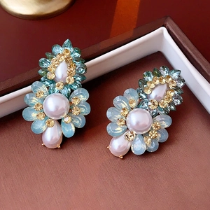 Détail macro de boucles d'oreilles vintage avec cristaux bleus et perles sur bois