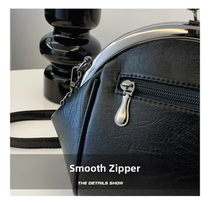 Detail view of smooth silver metal zipper and premium leather texture on vintage shell bag