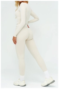 Close-up of cream high-waisted yoga leggings and long sleeve top with slim fit