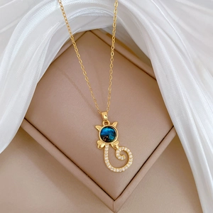 Detailed shot of cat pendant with blue starry gem and crystals in a beige jewelry box