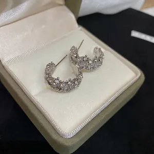 Boucles d'oreilles C en argent avec zircons étincelants dans une boîte luxueuse
