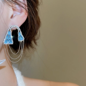Détail de la boucle d'oreille argentée avec pierres bleu ciel et franges