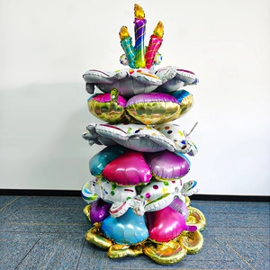 Close-up of a multi-tiered birthday cake balloon stand with colorful candles and polka dots