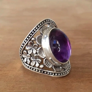 Vintage bohemian style silver ring featuring a large oval purple gemstone with floral carvings