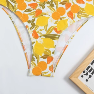 Close-up of tropical fruit print on white swimwear fabric with high-quality stitching