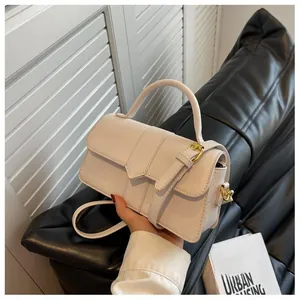 Gros plan du sac à bandoulière blanc minimaliste avec boucle dorée élégante