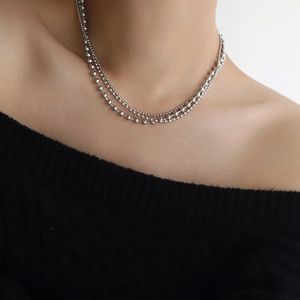 Silver double layer beaded necklace with minimalist industrial design on a black sweater