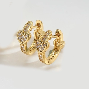 Detailed close-up of golden heart earrings with micro-pave cubic zirconia crystals