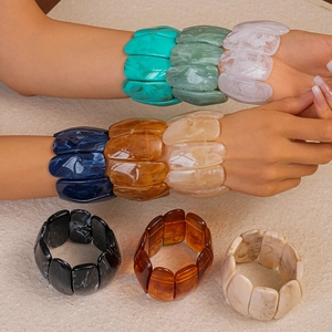 Detailed macro of elastic acrylic bracelets showing colorful marble ink textures