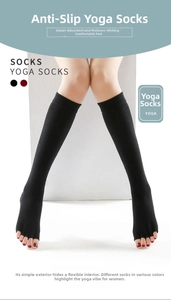 Detail of black over-the-knee yoga socks with open-toe design and ribbed knit texture