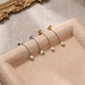 Boucles d'oreilles de luxe en or et argent avec perles d'eau douce sur présentoir velours