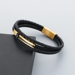 Detail of multi-layer black braided leather bracelet with gold magnetic metal clasp