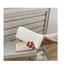 Detailed macro view of a white quilted PU leather long wallet with golden zipper detail