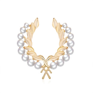 Detailed view of the golden laurel wreath brooch with symmetrical white round pearls