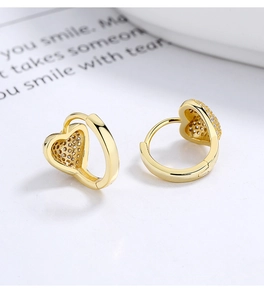 Detailed close-up of gold heart hoop earrings featuring shimmering pave diamond accents
