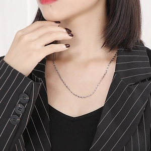 Close-up of a minimalist silver stainless steel paperclip necklace on a model's neck