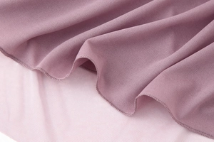 Detailed macro view of pleated purple chiffon fabric with fine rolled hem stitching