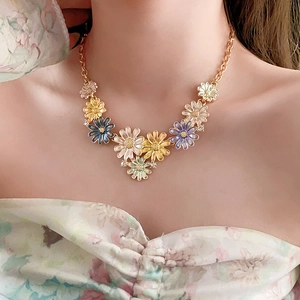 Close-up of a colorful daisy flower pendant necklace worn by a female model
