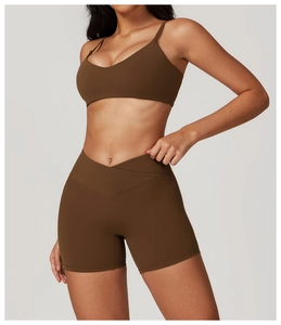 Detail of high-waist crisscross shorts and V-neck sports bra in matte chocolate fabric