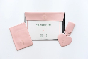 Detailed close-up of pink faux leather travel tag set including heart shaped bag charm